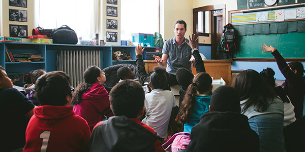 group of sitting children sitting in front of teacher